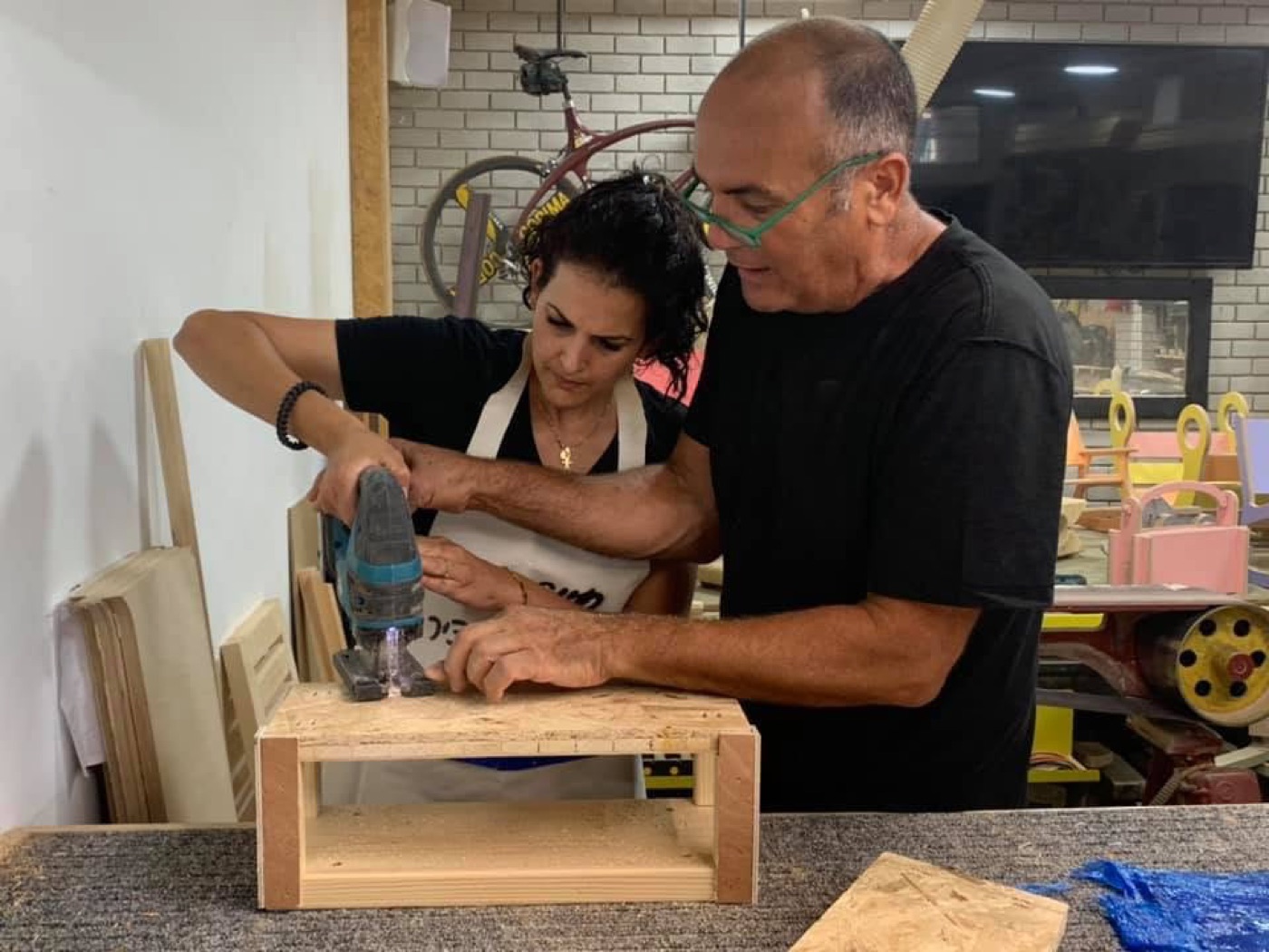 חיים מדריך משתתפת בעבודה עם מקדחה