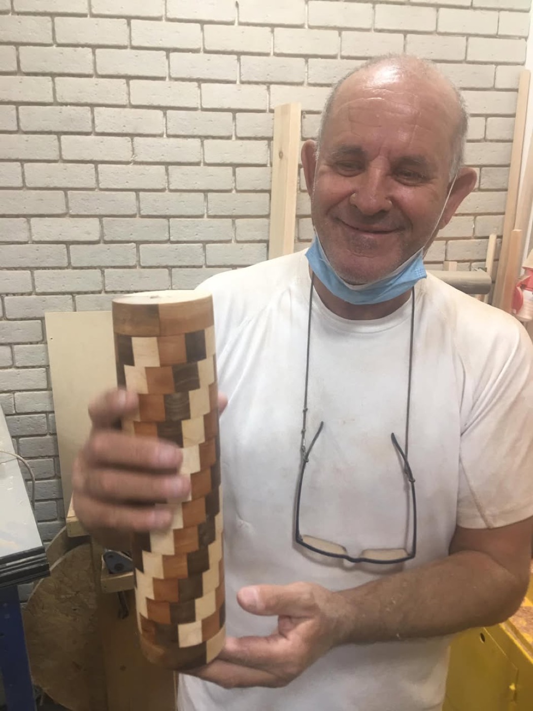 משתתף מחזיק בגאווה חלק עץ שהכין